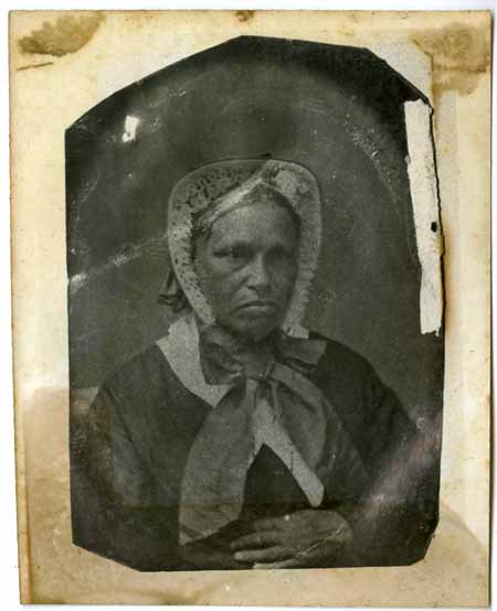 A black and white photo of a woman wearing a bonnet.