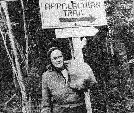 Gatewood stands near a sign for the Appalachian Trail with her denim sack of supplies