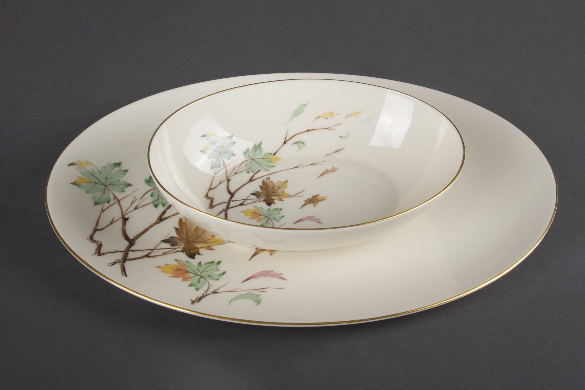 White bowl stacked on white plate with matching branch and leaf design