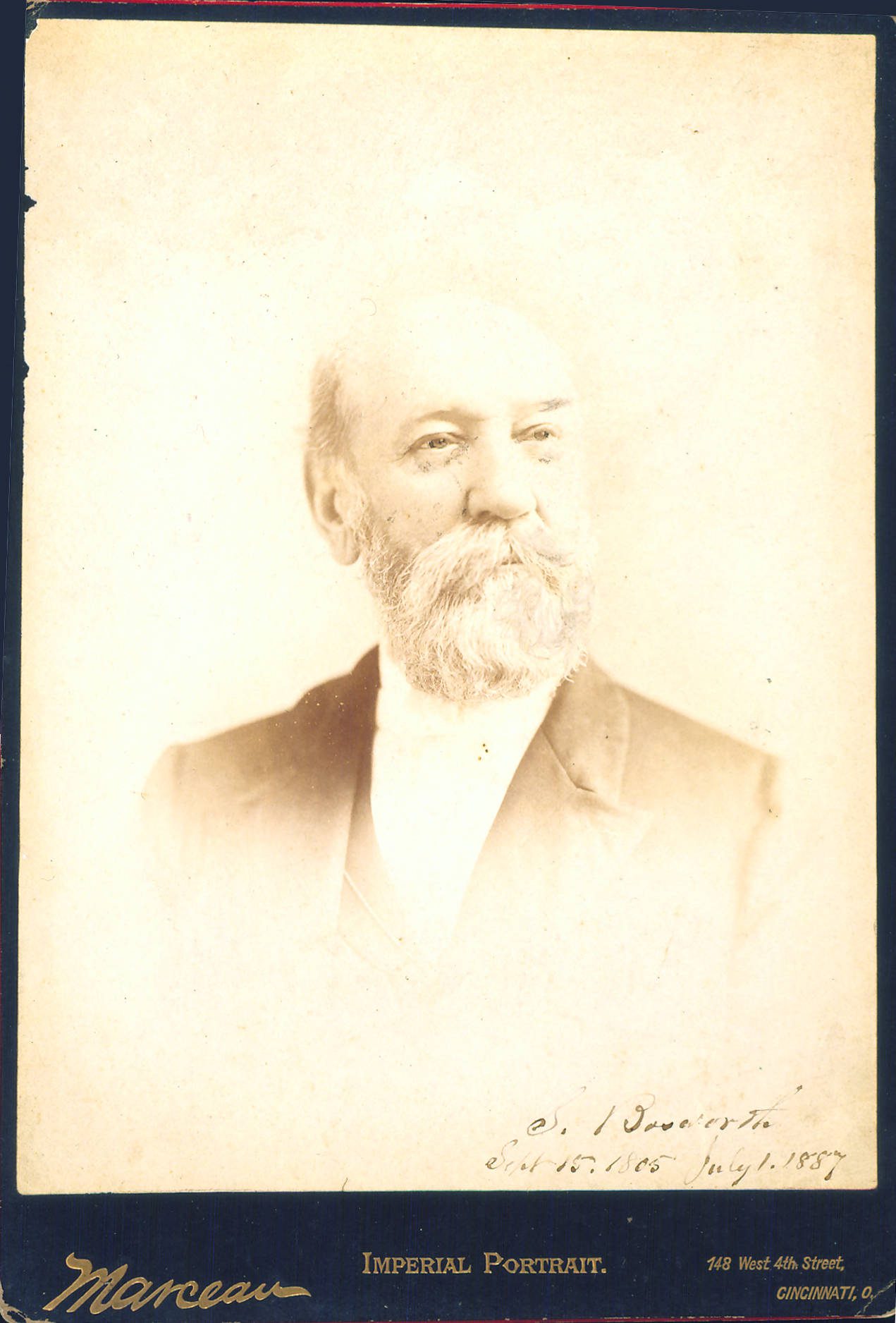 Sepia tone photographic portrait of a white man with a beard wearing a dark suit jacket and white shirt