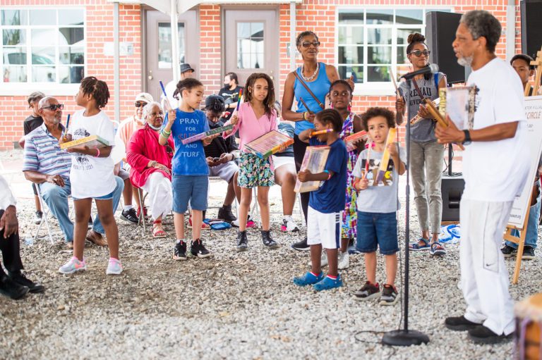Group of people participating on the Poindexter Village Drum Circle.