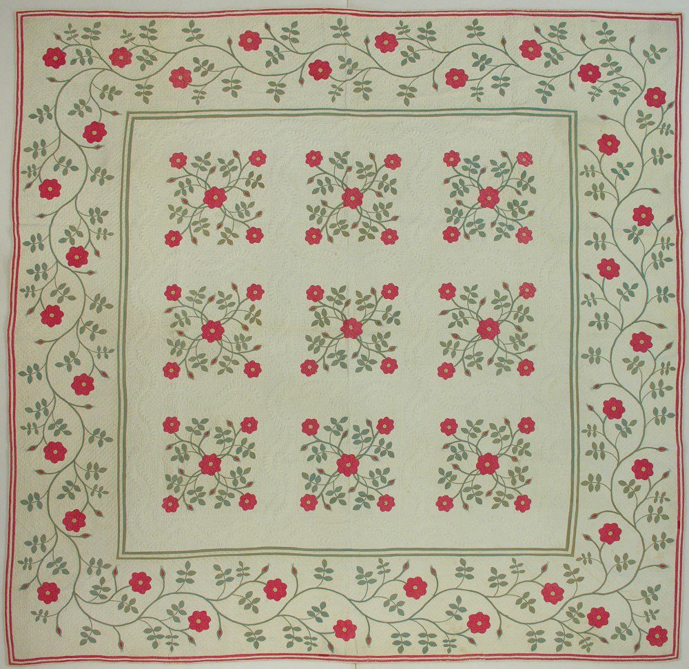 Red and green Rose of Sharon applique pattern on a white quilt