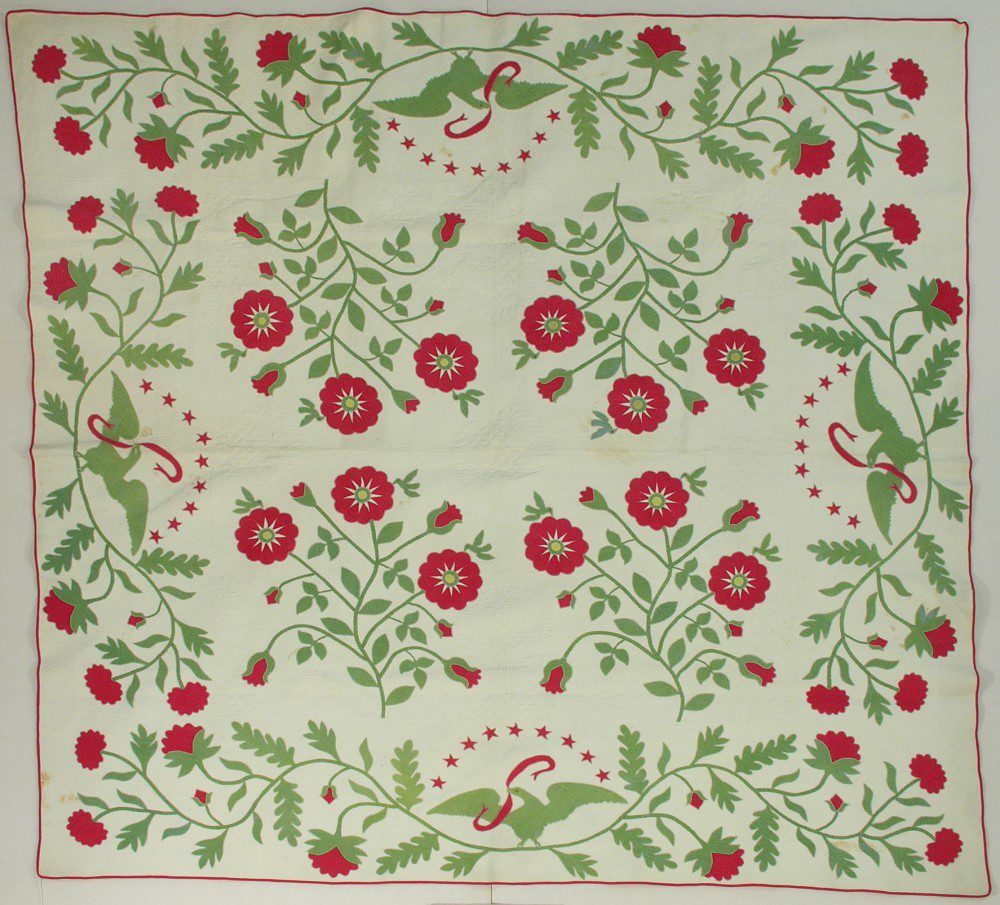 Red and green applique quilt in a star flower pattern