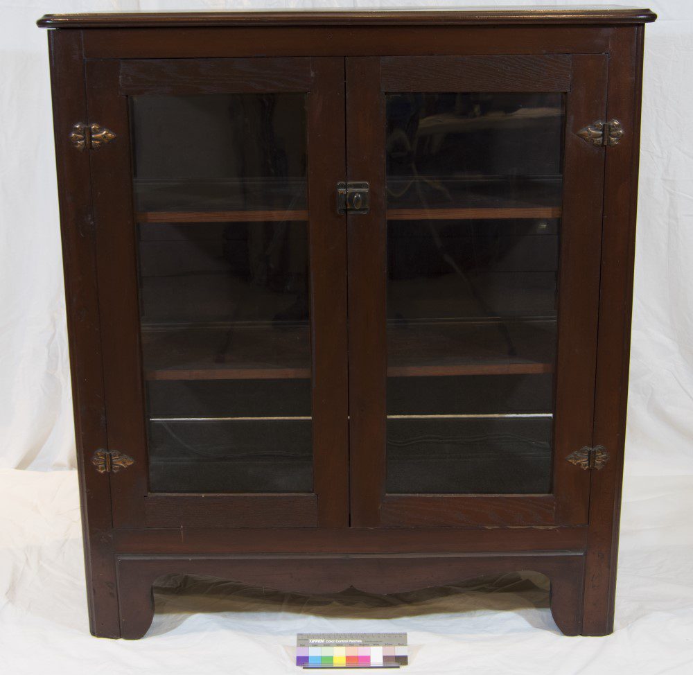 Photo of a short wooden cabinet with glass doors.