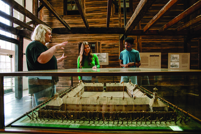 Visitors viewing a model of a fort as part of an exhibit at Campus Martius.