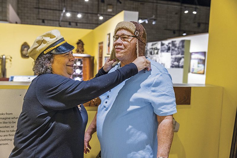 Visitors at the National Afro-American Museum and Cultural Center trying on hats.