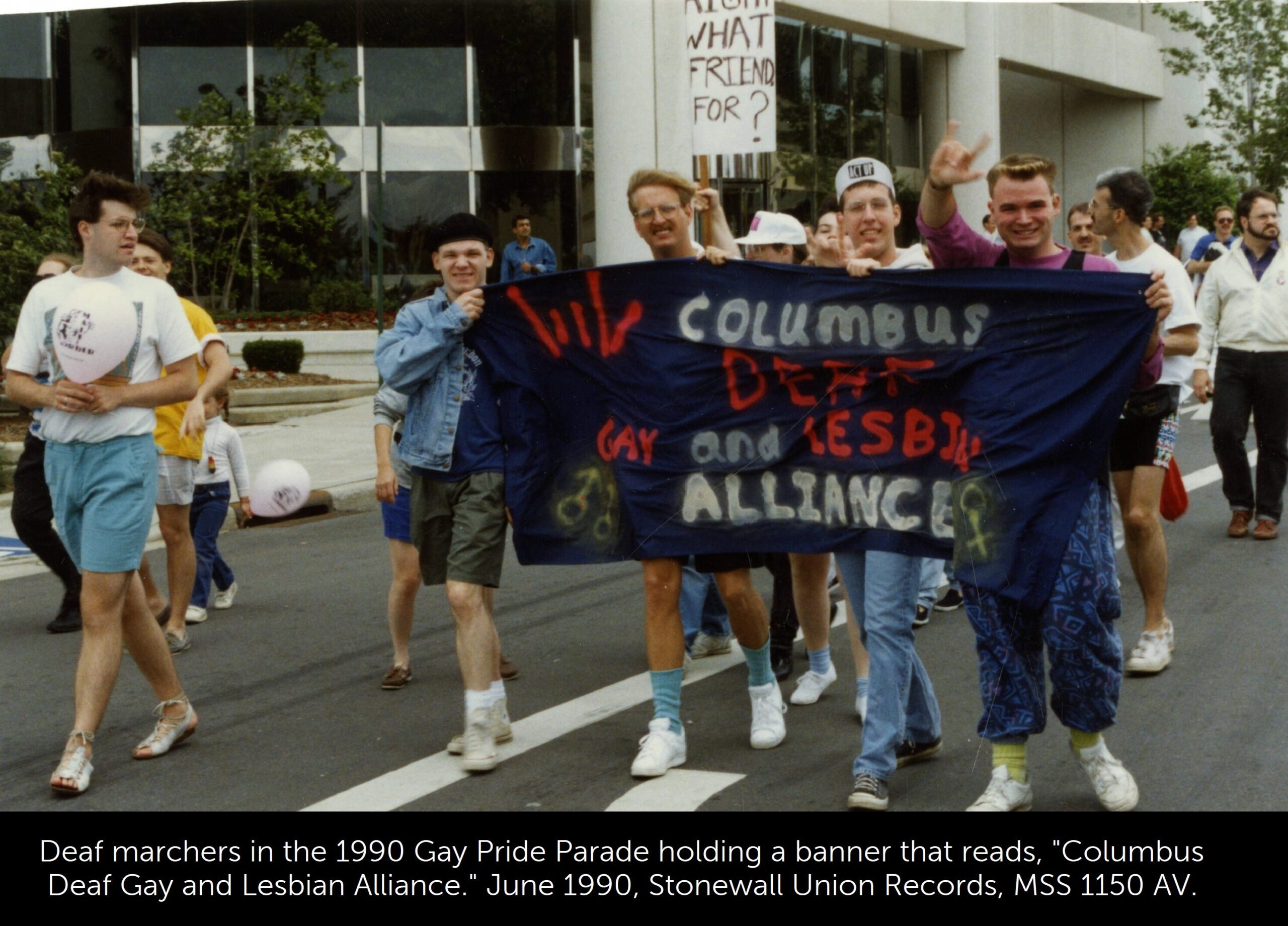 A photo of deaf marchers in the 1990 Gay Pride Parade holding a banner that reads, "Columbus Deaf Gay and Lesbian Alliance"