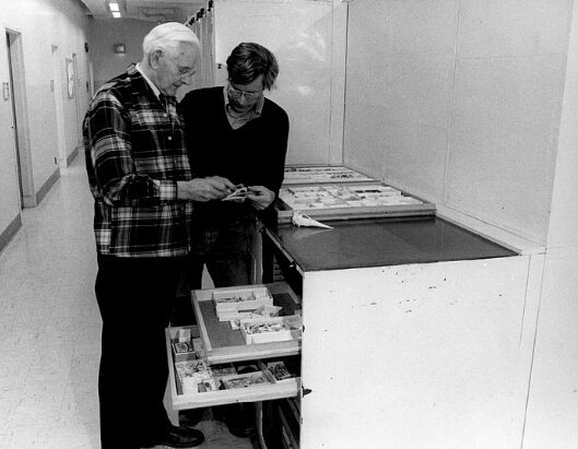 A photograph of Alexander Wetmore looking at bird bones with an unidentified man.