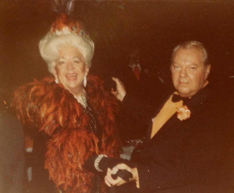 A female-presenting white person and a male-presenting white person, both in formal attire, dancing.