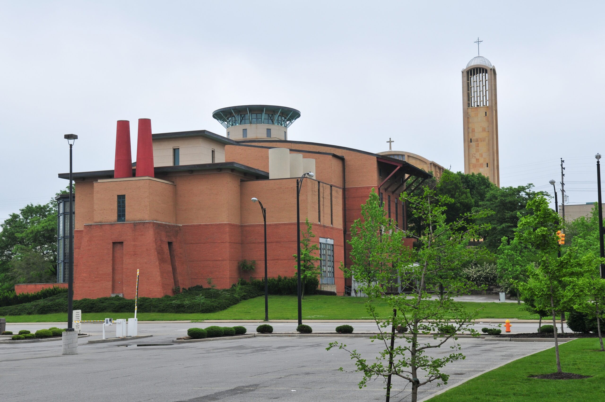 A large brick building in the background with some trees along the right side.