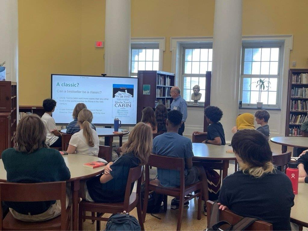 A group of students listening to a lecture and reading the associated PowerPoint.