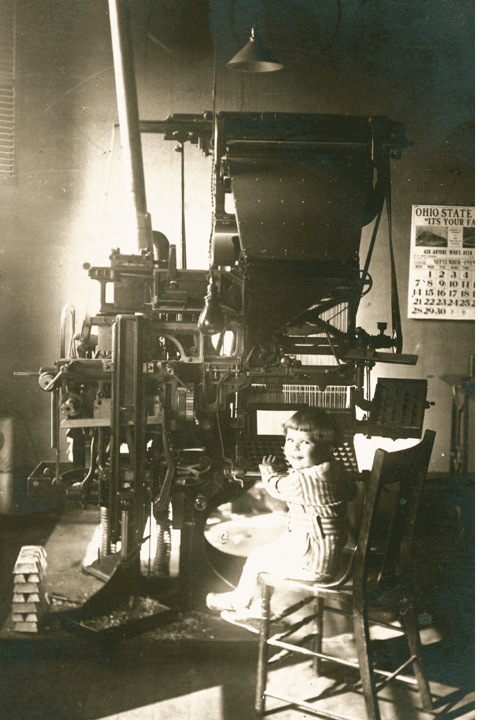 Young boy sitting at a Linotype machine in 1919