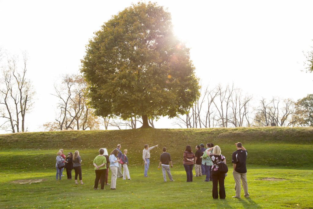 Image of people on a tour of the Newark Earthworks. Archaeologist Brad Lepper points out features of the Earthworks.