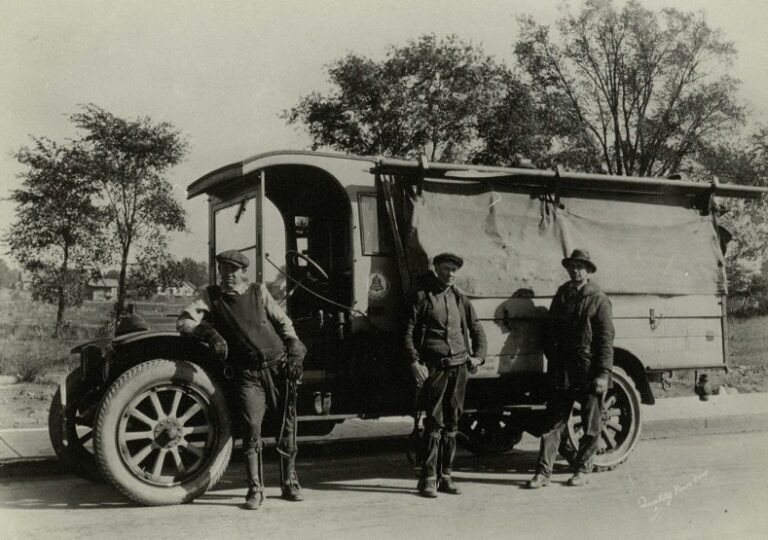 Black and white image of three Ohio Bell Telephone Company repairmen posing in front of a White Motor Company repair truck 