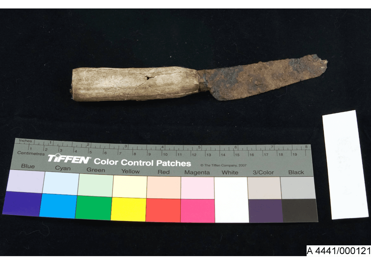 A rusted historic knife with a thick cracked handle.