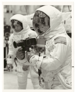 Apollo 11 Spacecraft Commander Neil Armstrong (front) and Lunar Module Pilot Edwin E. Aldrin (rear) practice lunar surface mobility at the Manned Spacecraft Center, Houston Armstrong has a camera attached to the chest area of the space suit. The astronauts are in pressurized space suits.