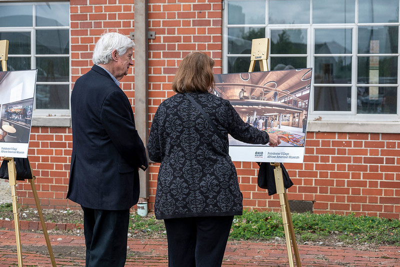 Visitors view the renderings on display during the groundbreaking for Poindexter Village.