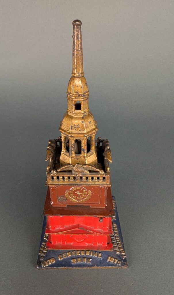 red, navy and gold cast iron still bank in shape of Independence Hall Tower