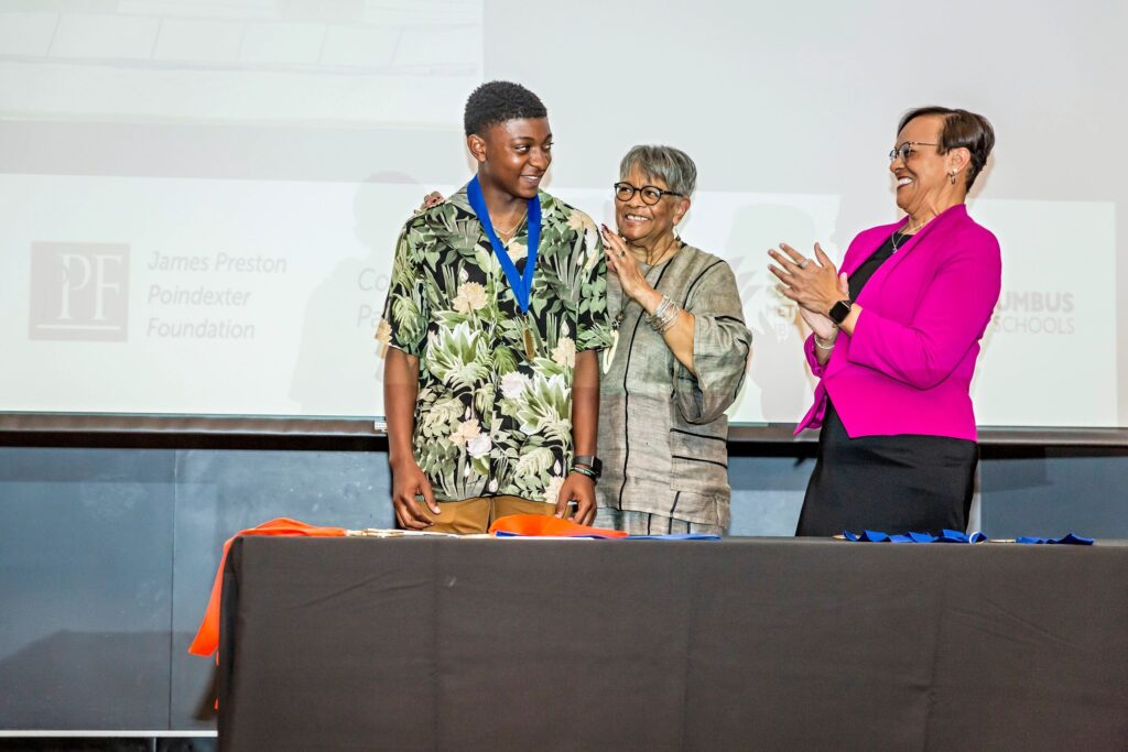 Poindexter Village Window of Stories Art Contest Winner receiving their medal.