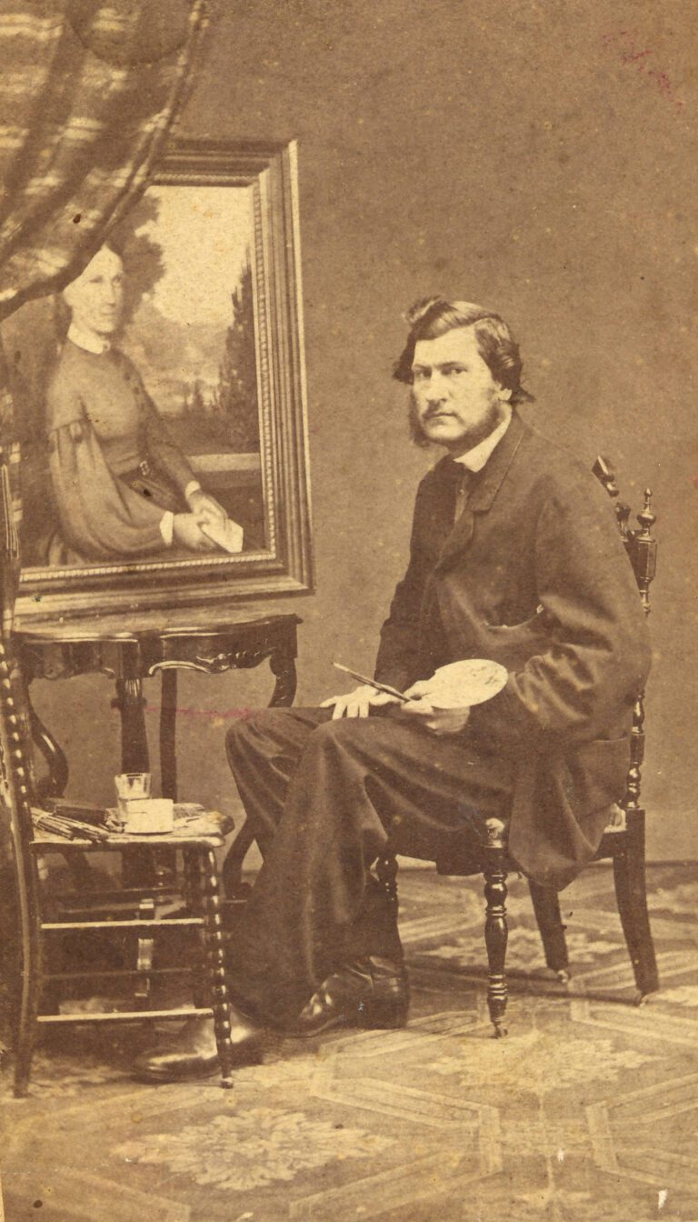 black and white photograph of an artist seated in front of a painting on an easel