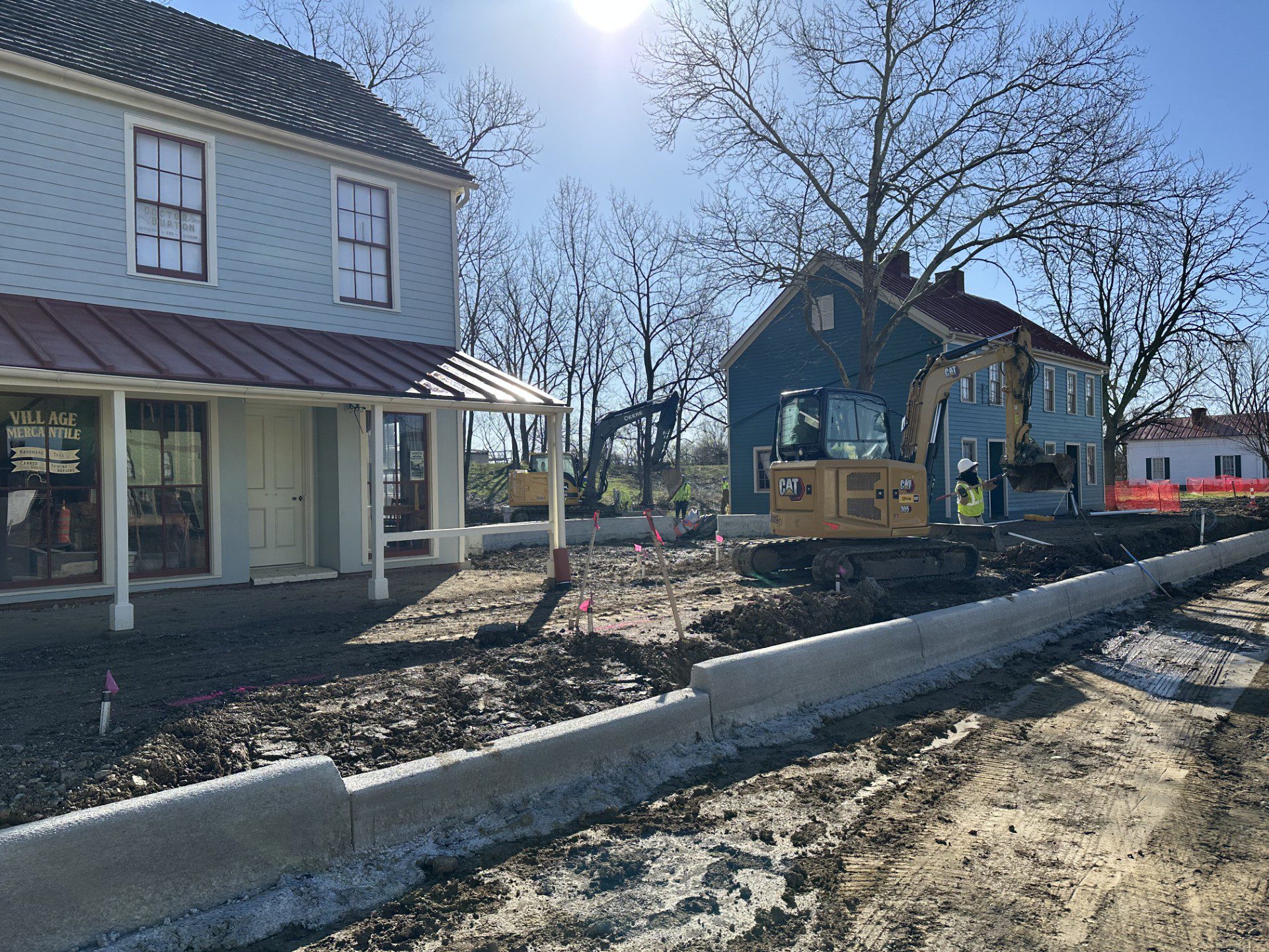New streetscape curbs are being laid outside of the village mercantile while workings continue on construction in the background.