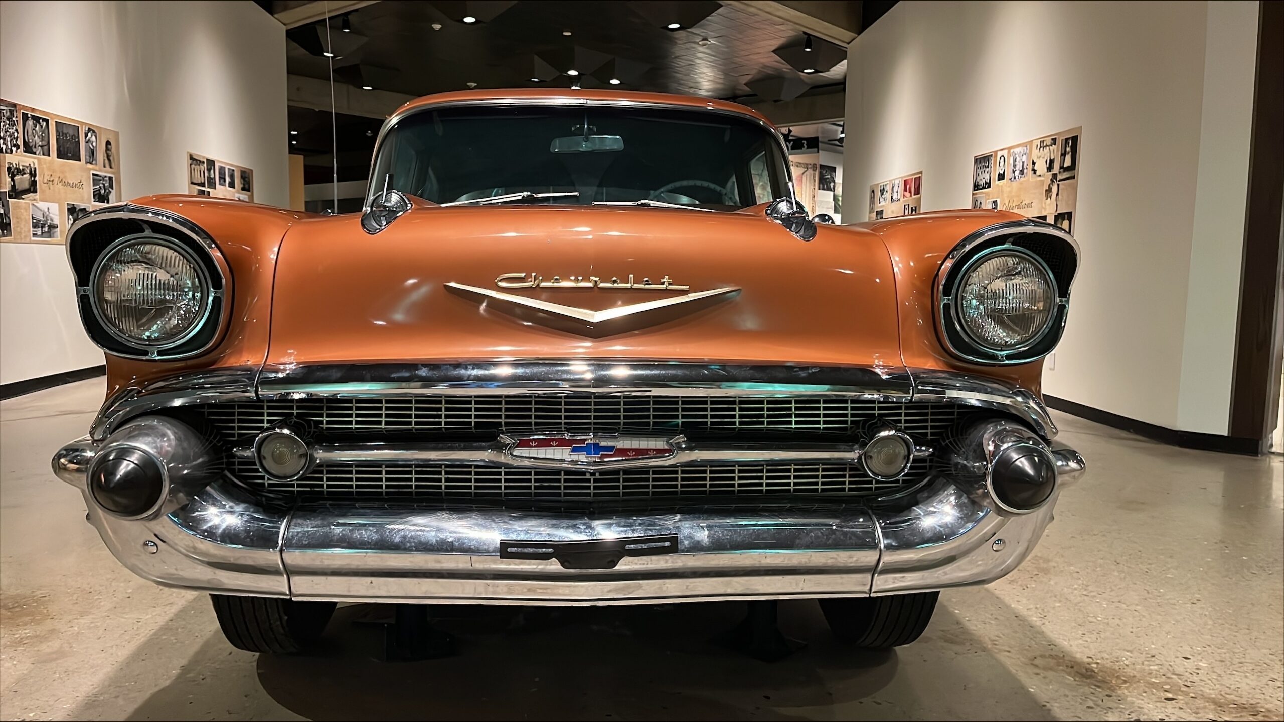 Photograph of the front of a copper-colored 1957 Chevrolet Bel Air showing the chrome bumper, grill, and headlights.