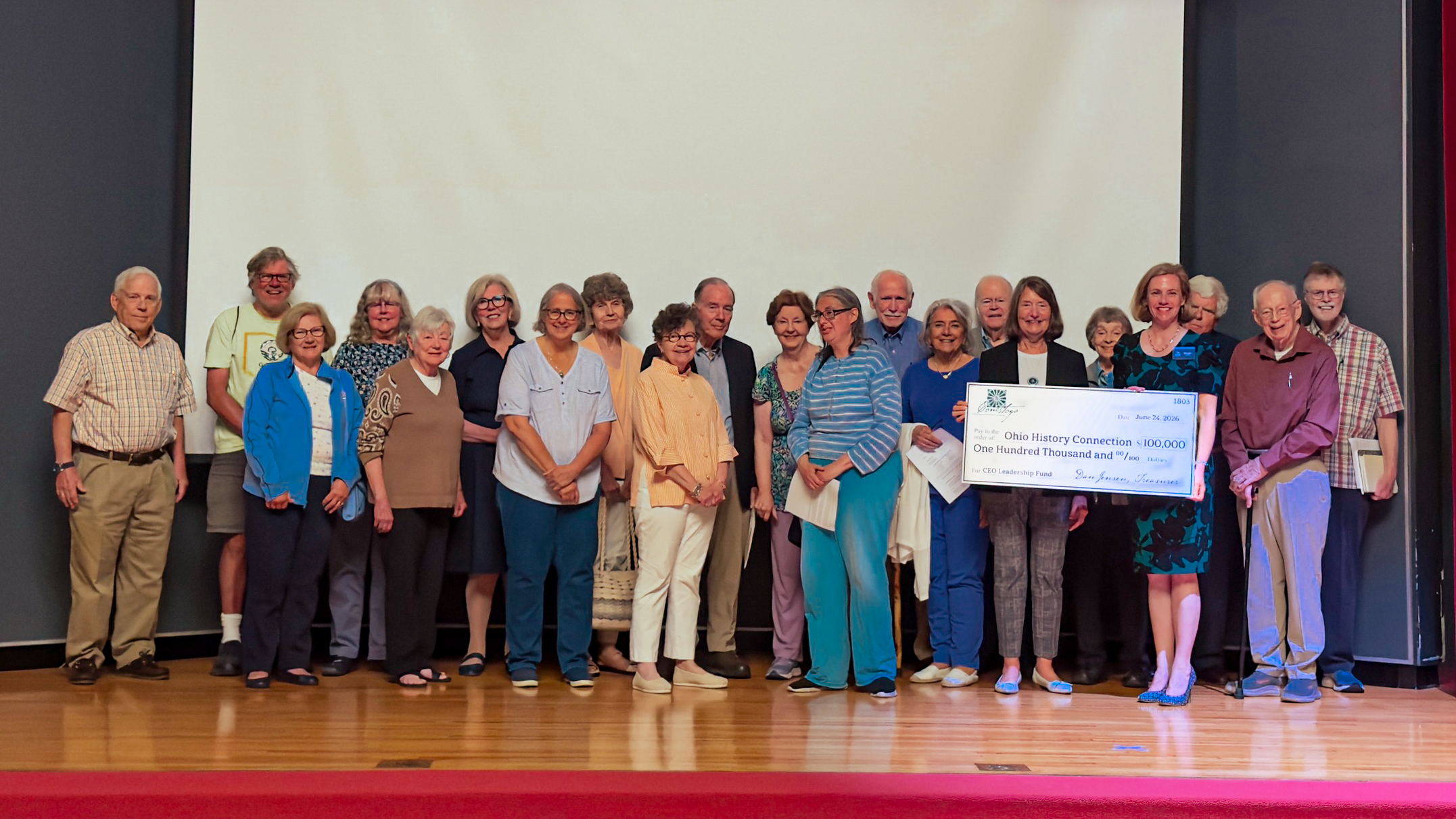 Image of Conestoga members and Executive Director Megan Wood with a giant check in the Ohio History Center auditorium.
