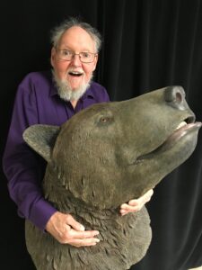 Dale Gnidovec holding a sculpture of the head of a short-faced bear.