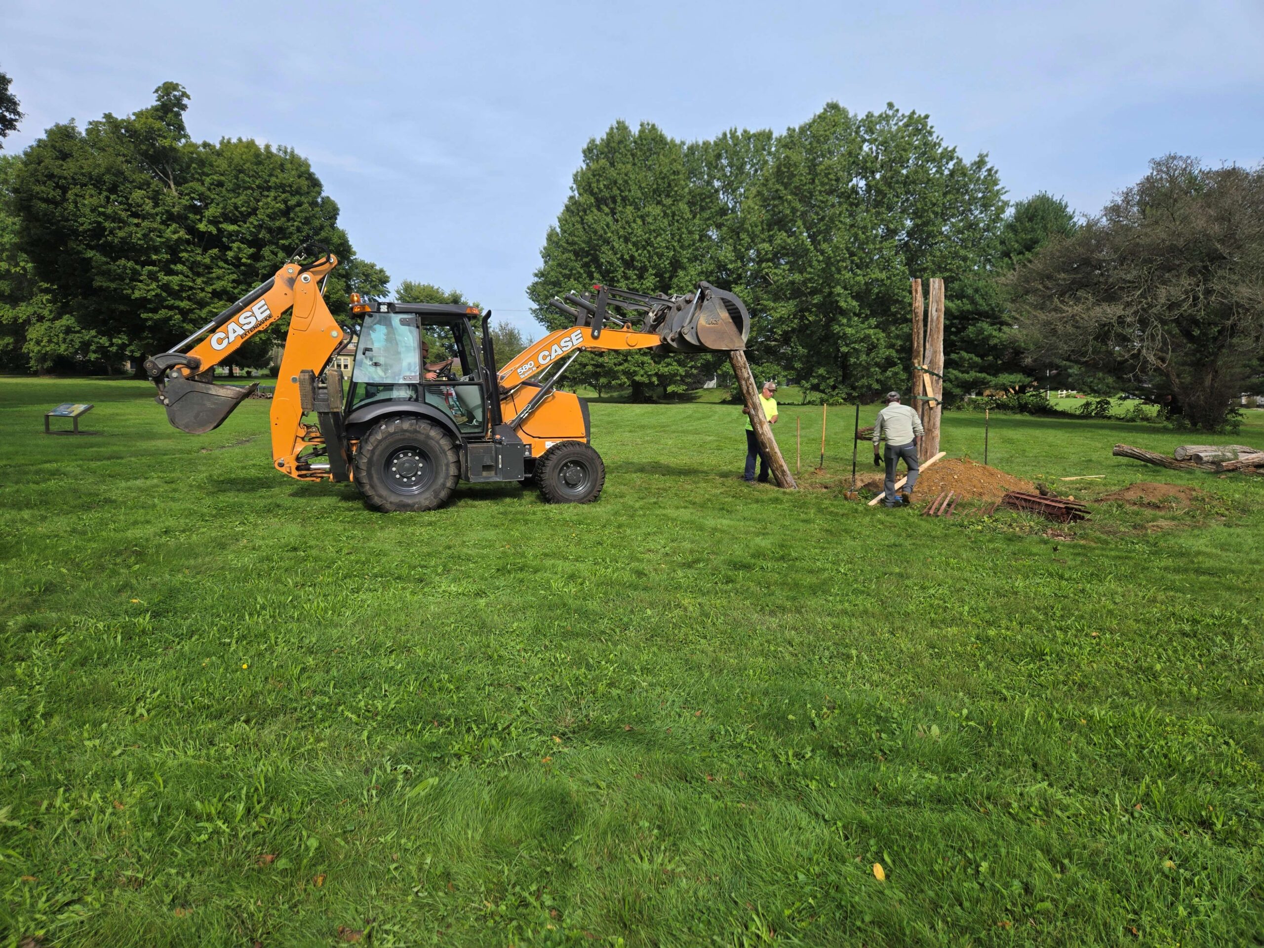 During the Fort Laurens for reconstruction in 2026, archaeologists use heavy machinery to raise a timber into place.