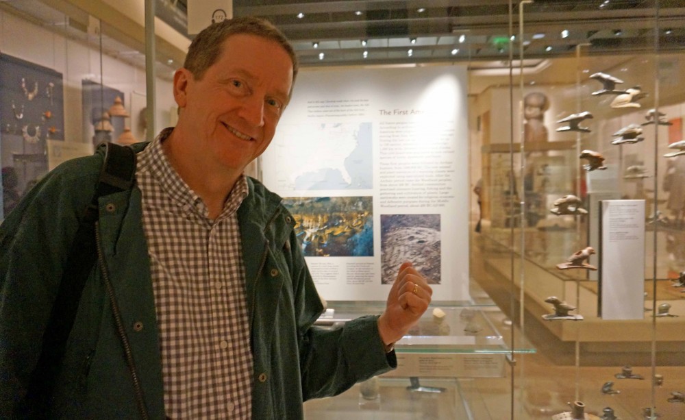 Brad Lepper at the British Museum pointing out the exhibit panel with images of Newark's Octagon Earthworks and Serpent Mound.